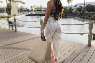 Woman carrying shopping bags walking on footpath