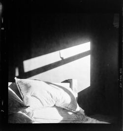 Rear view of man sitting on bed