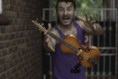 Man reaching for his levitating violin. 