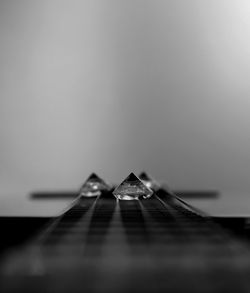 Close-up of broken glass on table against white background