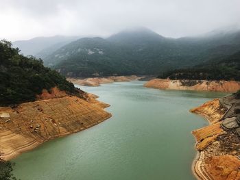 High angle view of river amidst mountains against sky