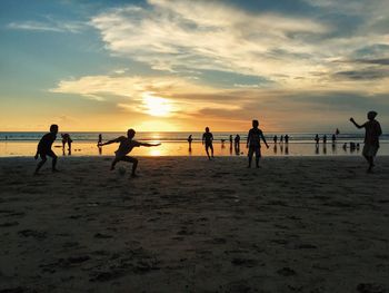 Silhouette of people enjoying on beach