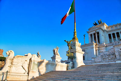 Low angle view of statues against blue sky