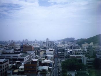 Cityscape against cloudy sky