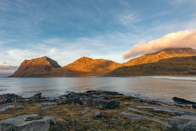 Scenic view of sea and mountains against sky