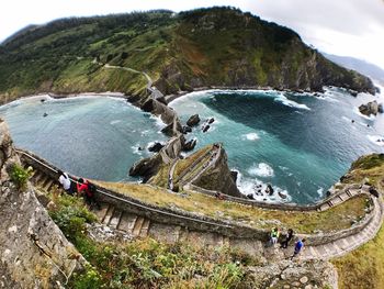 High angle view of sea by mountain against sky