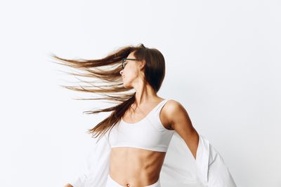 Rear view of young woman against white background