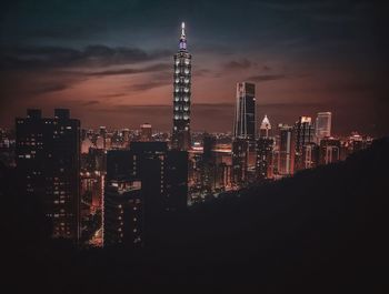 Illuminated buildings against sky at night