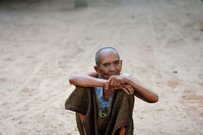 Portrait of smiling senior man sitting outdoors