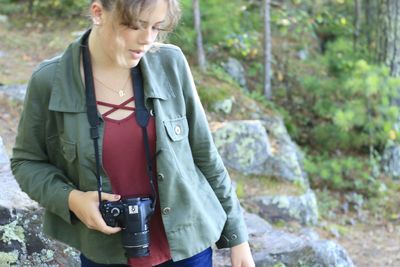 Midsection of a woman holding camera