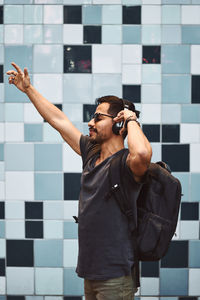 Man looking at camera while standing against wall