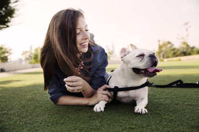 Portrait of young woman with dog on grass