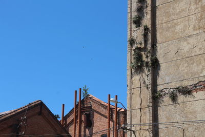 Low angle view of old building against clear blue sky