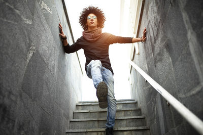 Low angle view of young man on steps against sky