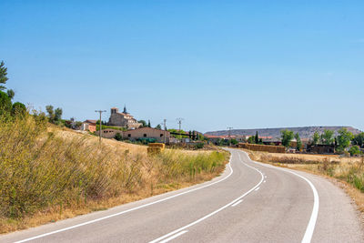 A empty road with curves crossing fields of crops