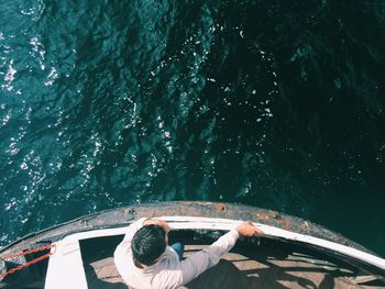 Directly above shot of man standing by railing in boat on sea