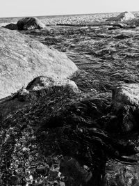 Close-up of rocks on shore against sky