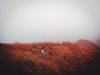 Man standing on field against sky