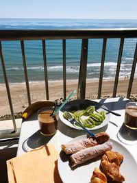 Food on table at beach against sky