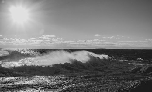 Scenic view of sea against bright sun