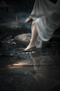 Low section of woman standing in water