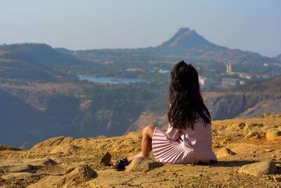 Rear view of woman looking at mountain against sky