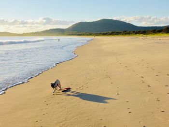 People riding on beach against sky