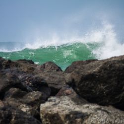 Surface level of rocky beach against sky