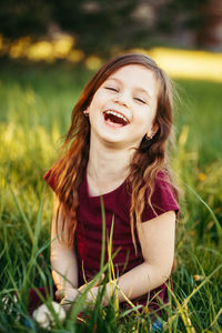 Cheerful girl sitting on field