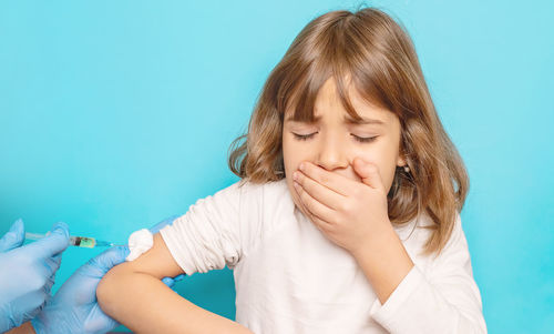 Girl taking vaccination from doctor