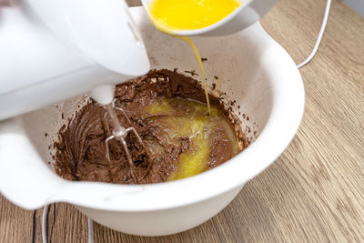 Mixing the dough with a hand mixer with a whisk with melted butter added, the dough is thick mass.