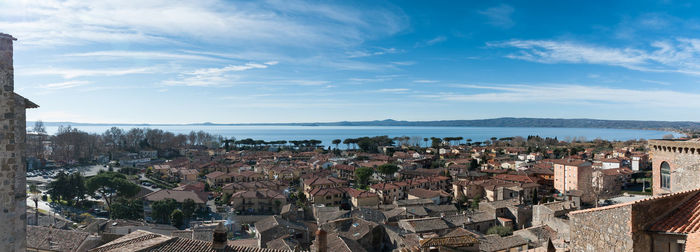 Panoramic view of cityscape by sea against sky