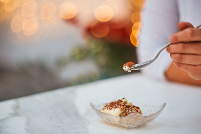 Close-up of hand holding ice cream on table