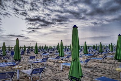 Chairs on beach against sky