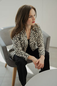 Portrait of young woman sitting at home