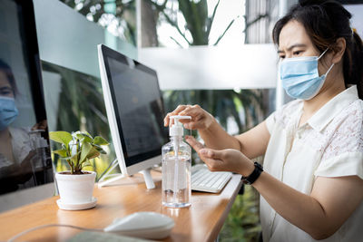 Woman using mobile phone while sitting on table