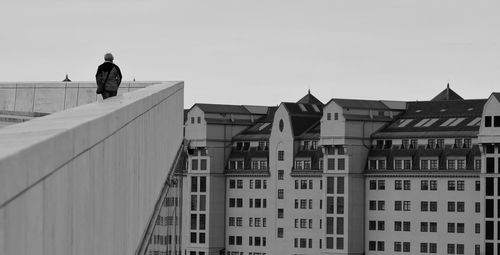 Rear view of man standing against buildings