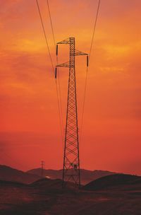 Low angle view of silhouette electricity pylon against romantic sky at sunset