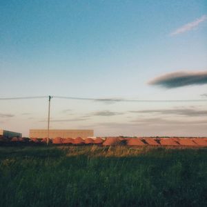 Scenic view of field against cloudy sky