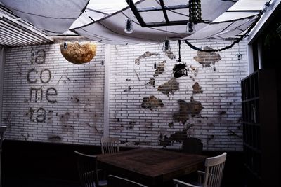 Table and chairs against wall in building