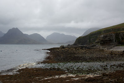 Scenic view of river and mountains against sky