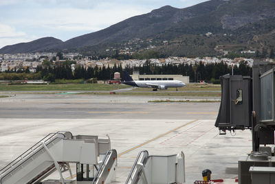 Airplane on runway against mountains