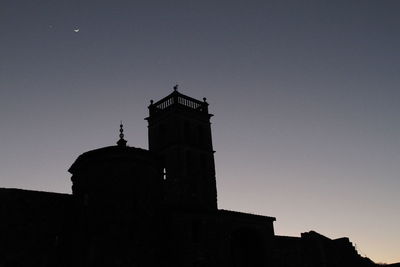 Low angle view of silhouette building against clear sky