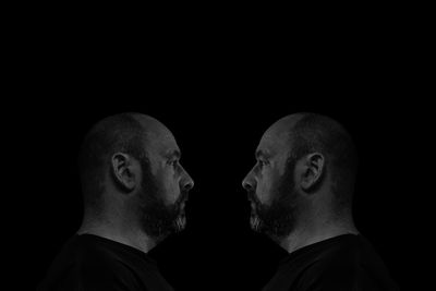 Portrait of young man against black background