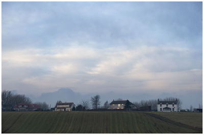Houses on field against sky