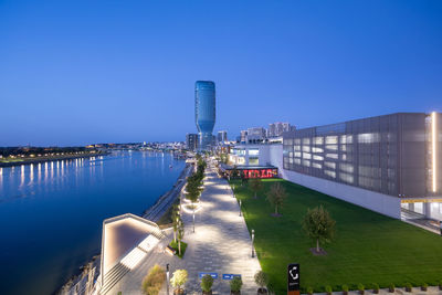 High angle view of buildings in city against clear blue sky