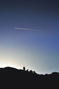 Silhouette landscape against clear blue sky