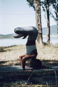 Side view of woman exercising on field