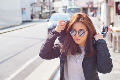 Woman in sunglasses walking on road