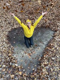 High angle view of woman standing on yellow leaves